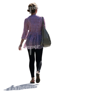 backlit woman walking on the street