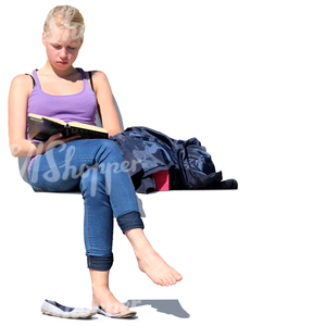 teenage girl sitting outside and reading a book