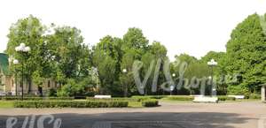 view of a park with benches and street lamps