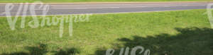 grass field with asphalt road