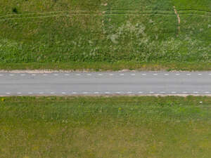 above view photo of a road between graslands