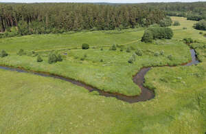 aerial view of a river flowing between meadows