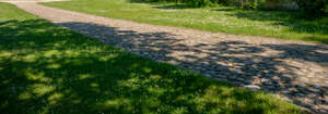 cobblestone road between grass fields