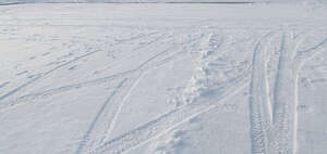 even field of snow with tyre tracks