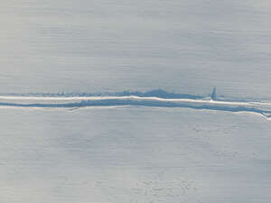 aerial view of a road through snowy fields