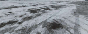 asphalt field covered with snow and ice