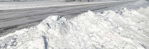 road in winter lined with heaps of snow