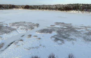 aerial view of a frozen forest lake
