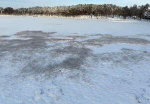 aerial view of a frozen forest lake