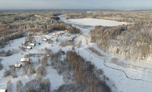 aerial view of countryside with houses and lake in winter