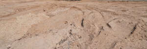 field of sand with tyre tracks