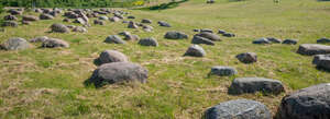 grassy field with rubble stones