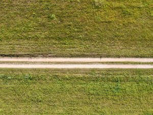 top view of a road between grass fields