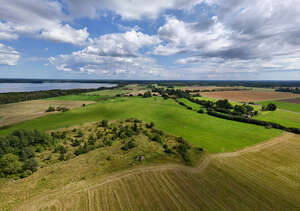 bird eye view of a landscape with fields by the sea