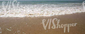 frothy waves on a sandy ocean beach