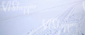 field of snow with snowmobile tracks