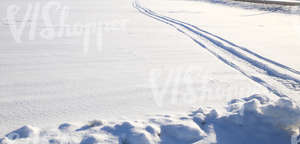 field of snow with snowmobile tracks