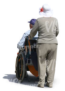 elderly woman pushing a man in a wheelchair