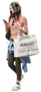 woman carrying a big shopping bag walking and listening to music