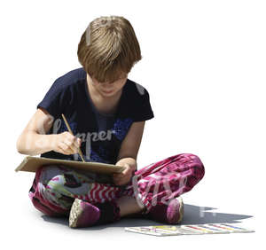 girl sitting on the ground and painting