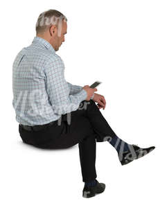 man sitting and looking at his phone