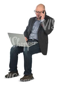 man sitting with a laptop on his knees and working