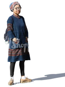 elderly asian woman in ethnic clothes standing in the sunlight