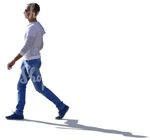 backlit young man in a white sweater walking