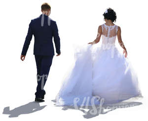 backlit bride and groom walking side by side