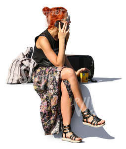 red haired woman sitting and talking on the phone