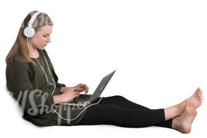 girl sitting on a couch and listening to music from her laptop