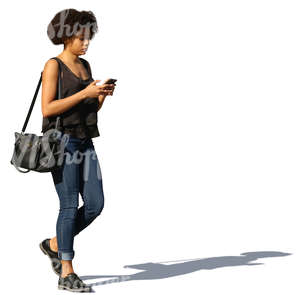 african woman walking and texting