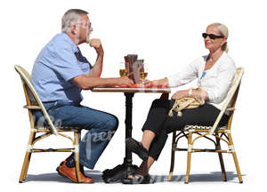man and woman sitting in a cafe and drinking wine