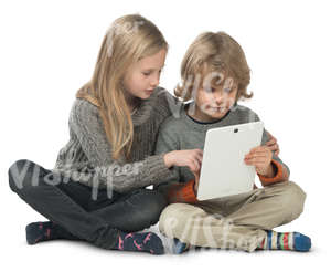 little boy and girl sitting on the floor and looking at ipad