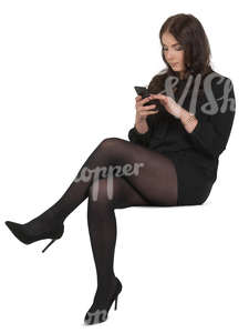 woman in a black costume sitting and texting