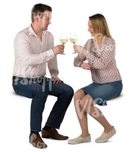 man and woman sitting in a cafe and drinking wine