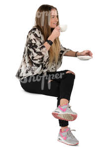 young woman sitting in a cafe and drinking coffee