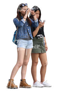 two teenage asian girls standing and taking a picture