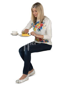 woman sitting in a cafe and eating cake