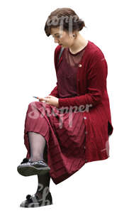 woman in a red costume sitting and texting