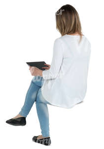 woman sitting and looking at a tablet