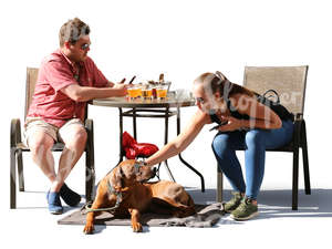 man and woman with a dog sitting in a cafe