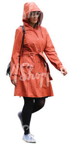 woman in an orange raincoat walking