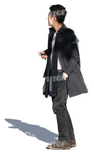 asian man wearing a black coat standing