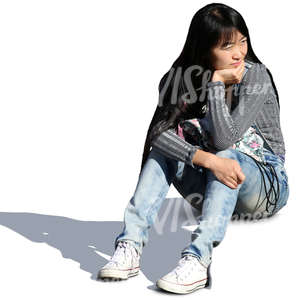asian woman sitting on the sidewalk
