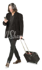 man with a suitcase walking and checking his phone