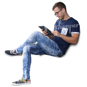 man sitting and looking at his tablet