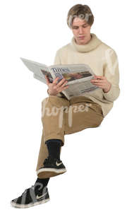 young man sitting and reading a newspaper