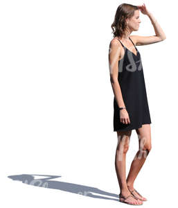 woman in a black summer dress standing and looking