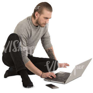 man sitting on the floor and working with laptop